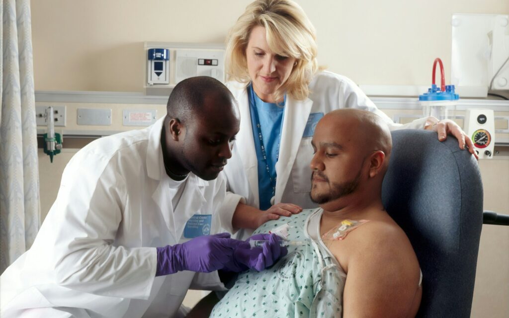 Cancer patient receiving treatment from healthcare professionals in a hospital setting