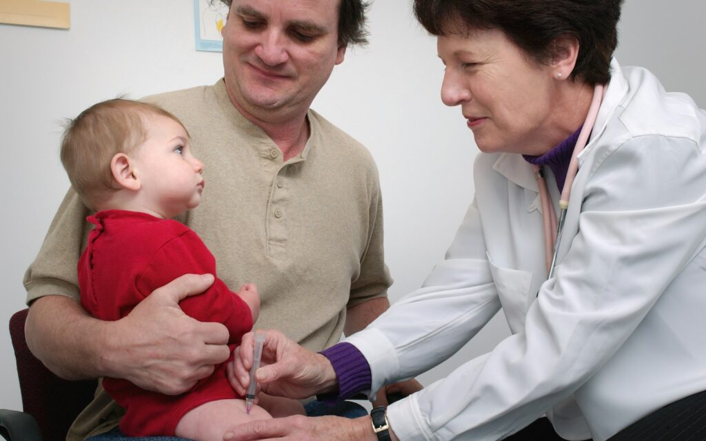 Pediatrician examining an infant during a clinic visit