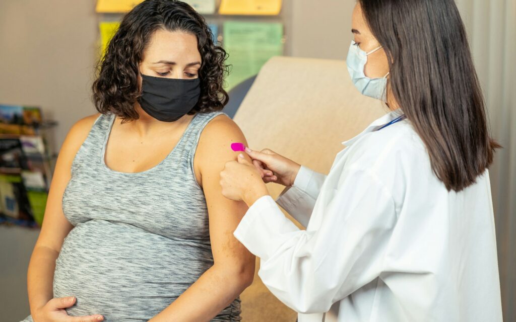 Pregnant woman receiving vaccination in a clinical setting