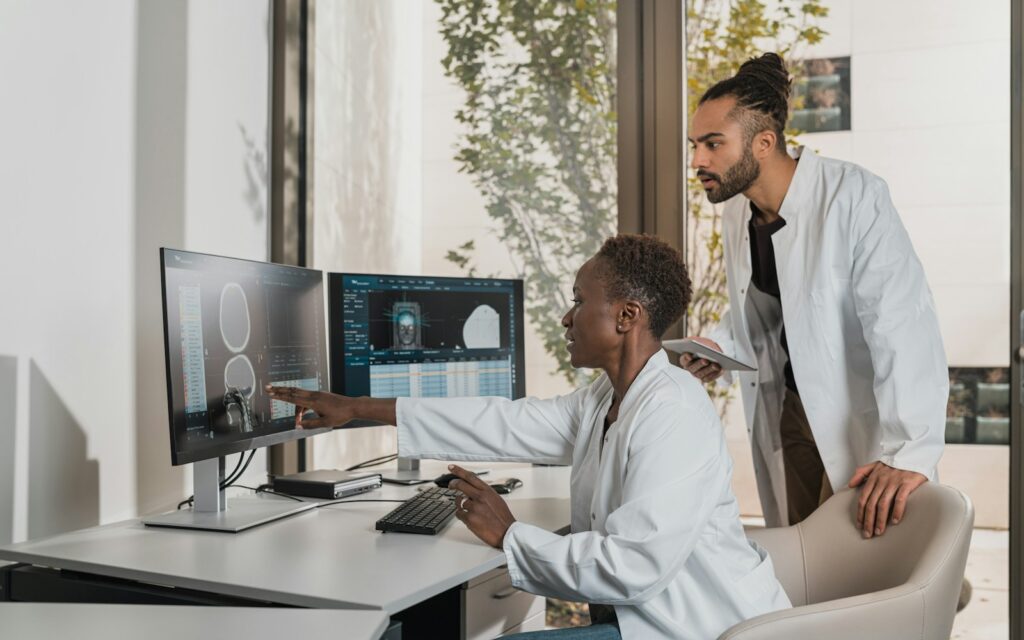 Medical professionals reviewing brain scans on monitors